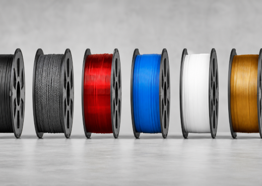Bobinas de filamento em várias cores: preto, vermelho, azul, branco e dourado